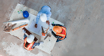 Aerial view of a construction crew planning at a table on a construction site